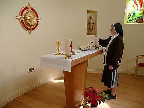 Sister preparing the altar for Mass in the chapel