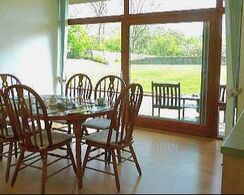 Dining table and chairs and window looking over gardens