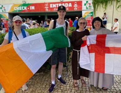 Students and a Sister at World Youth Day holding up flags