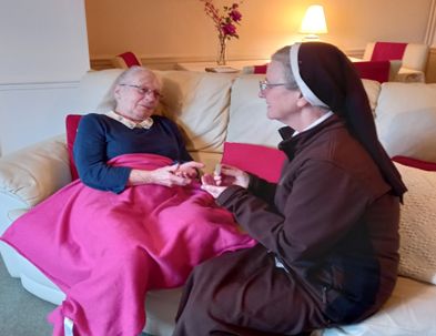 Parish Sister sits with a parishioner in their home